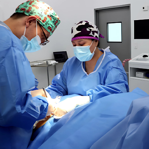 Dr. Néstor Velasco realizando cirugía vascular de varices en quirófano del Manta Hospital Center junto al equipo Lifebridge Medical & Surgical Services